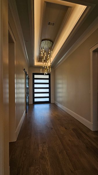 Interior hallway chandelier with overhead cove lighting, Elite AVL, accent lighting in Texas home