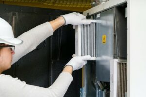 Technician replacing a filter on indoor air quality system.