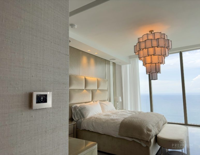 Crestron Home system display in miami luxury condo primary suite overlooking oceanside