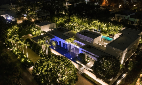 Overview shot of florida mansion, ETC, landscape lighting at night, tropical oasis setting